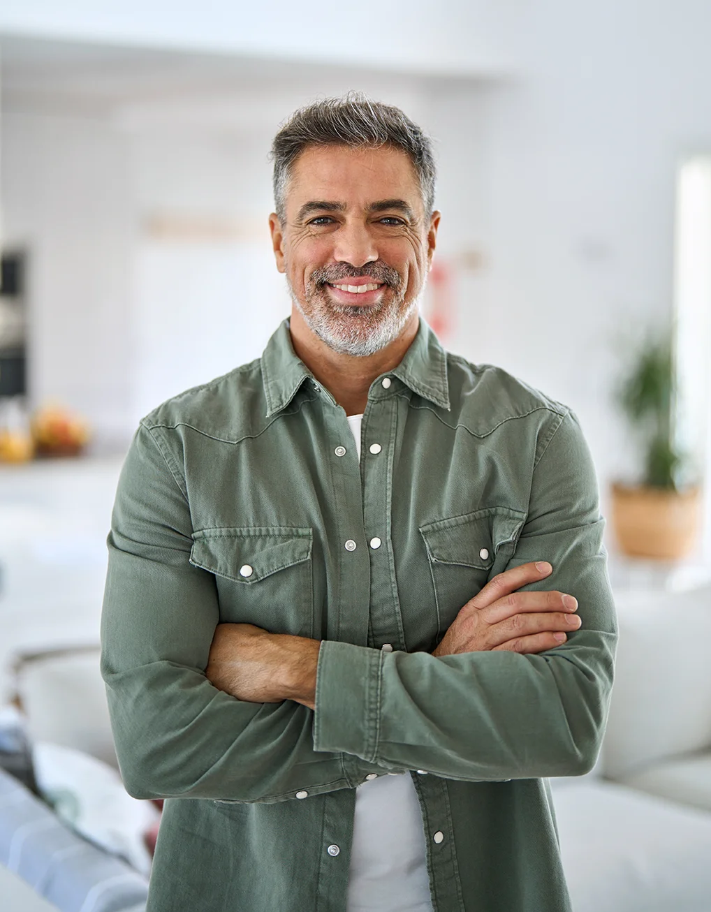 Happy confident middle aged senior man standing with arms crossed at home.
